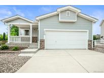 Charming home with attached two-car garage, covered porch and stone accents at 9620 Mallard Pond Way, Littleton, CO 80125