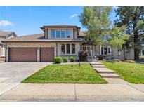 Charming two-story home with a well-manicured lawn, beautiful landscaping, and a spacious three-car garage at 2154 S Parfet Dr, Lakewood, CO 80227