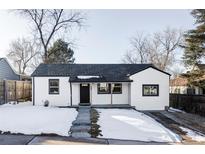 Charming white house with dark gray roof, landscaping, and snowy front yard at 657 Newton St, Denver, CO 80204