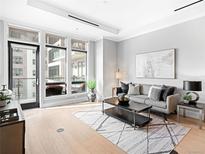 Bright living room boasts floor-to-ceiling windows and access to a private balcony with outdoor seating at 7600 Landmark Way # 914, Englewood, CO 80111
