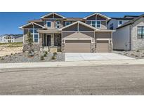 Beautiful two-story home featuring a two-car garage and stone accents, enhancing its curb appeal at 4748 Weitbrec Ln, Castle Rock, CO 80104