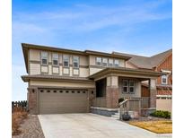 Inviting two-story home featuring a covered front porch and attached two-car garage at 1669 Stable View Dr, Castle Pines, CO 80108