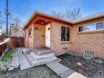 Charming brick home featuring a quaint front entrance with concrete steps and manicured landscaping at 732 Poplar St, Denver, CO 80220