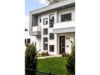 Modern two-story home with gray and white exterior, balcony, and manicured lawn at 6435 E 6Th Avenue Pkwy, Denver, CO 80220