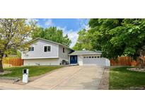 Charming split-level home with a well-maintained front yard, a two-car garage, and a blue door at 5389 W Roxbury Pl, Littleton, CO 80128
