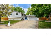 Charming two-story home with a well-manicured lawn, a driveway, and a two car garage at 5389 W Roxbury Pl, Littleton, CO 80128