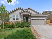 Charming single-story home boasts stone accents, a two-car garage, and a well-manicured lawn at 6484 S Harvest St, Aurora, CO 80016