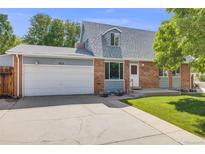 Charming two-story home with brick facade, attached garage, and well-maintained lawn in a quiet neighborhood at 12218 Monroe Dr, Thornton, CO 80241