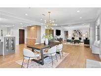Bright dining area with stylish lighting fixture, seating for six, and adjacent to living room with an open concept at 1590 Little Raven St # 408, Denver, CO 80202