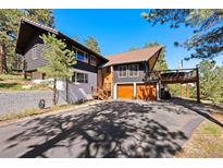 Inviting exterior showcasing a two-story home, a spacious driveway, and a two-car garage at 2976 Hiwan Dr, Evergreen, CO 80439