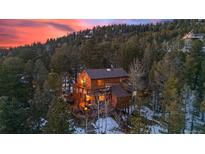 Stunning two-story cabin nestled among trees with a spacious deck and mountain views at 31207 Kings Valley Dr, Conifer, CO 80433