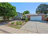 Charming home with a blend of brick and siding, complemented by a well-maintained yard and mature trees at 9222 Albion St, Thornton, CO 80229