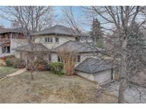 Charming home with a gray roof and neutral siding, complemented by mature trees and lush landscaping at 1590 S Milwaukee St, Denver, CO 80210