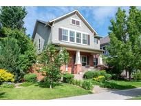 Charming two-story home featuring manicured lawn, brick accents, and inviting front porch at 817 Uinta Way, Denver, CO 80230