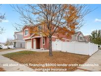 Charming two-story home featuring a two-car garage, white fence, and a lovely front yard with mature tree at 5552 Flanders Way, Denver, CO 80249