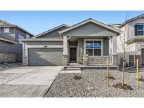 Gray exterior with two-car garage, front porch, and landscaping at 261 Paloma Way, Elizabeth, CO 80107