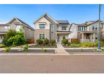 Charming two-story home featuring stone accents, a front porch, and solar panels at 10295 E 59Th Ave, Denver, CO 80238