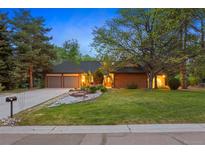Charming brick home featuring a well-manicured lawn, mature trees, and a two-car garage at 5735 Big Canon Dr, Greenwood Village, CO 80111