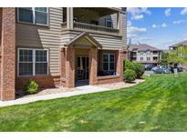 Inviting condo with brick and siding exterior, covered patio, and well-maintained landscaping at 12914 Ironstone Way # 102, Parker, CO 80134