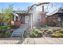 Charming brick home with front yard landscaping, stone steps, and a cozy covered front porch at 328 S Lincoln St, Denver, CO 80209