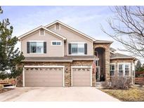 Charming two-story home with stone accents, attached three car garage and manicured lawn at 5881 Lasso Pl, Parker, CO 80134