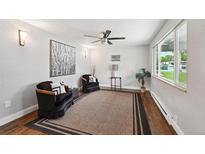 Bright living room featuring hardwood floors, a ceiling fan, stylish furnishings, and plenty of natural light at 3930 S Hazel Ct, Englewood, CO 80110