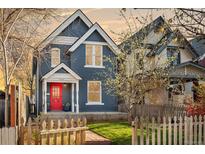 Charming two-story home with blue siding, white trim, a red door and a lovely landscaped yard at 3142 W 26Th Ave, Denver, CO 80211
