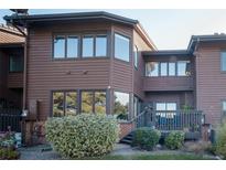 Townhome exterior featuring wood siding, updated windows, and a small deck at 5845 W Mansfield Ave # 259, Denver, CO 80235