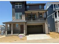 Inviting two-story home with a stone facade, a balcony, and a spacious two-car garage at 6717 E 149Th Ave, Thornton, CO 80602