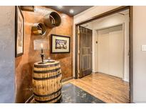 Charming hallway featuring a decorative barrel table, unique wall decor, and convenient elevator access at 1735 19Th St # 5B, Denver, CO 80202