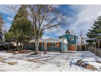 Beautiful two-story home with a striking blue exterior, wood garage door, and landscaped yard at 1120 Hartford Dr, Boulder, CO 80305