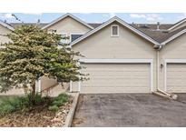 Home's exterior showing a two car garage and lovely tree in the front at 228 Quari St, Aurora, CO 80011