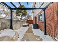 Cozy backyard patio area with brick flooring, pergola and privacy fence, perfect for outdoor relaxation at 9886 Appletree Pl, Thornton, CO 80260