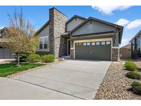Charming home with a stone chimney, three-car garage, and well-manicured front yard at 3429 Goodyear St, Castle Rock, CO 80109