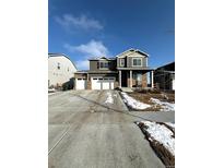 Beautiful two-story home with a three car garage and stone accents on a sunny day at 7435 E 159Th Pl, Thornton, CO 80602