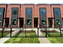 Modern brick townhomes featuring private fenced yards and black-trimmed windows offer stylish curb appeal at 115 W 2Nd Ave # 104, Denver, CO 80223