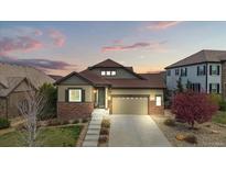 Charming single-Gathering home with brick accents, a well-manicured lawn, and a two-car garage at 7790 S Queensburg Way, Aurora, CO 80016