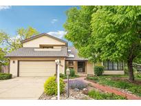 Charming home with a well-manicured lawn, mature trees, and inviting walkway at 11285 Ranch Pl, Denver, CO 80234