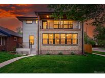 Two-story home with a brick and siding facade, large windows, balcony, and well-manicured lawn at 2391 Hudson St, Denver, CO 80207