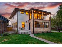 Beautiful two-story home with brick and siding exterior, covered porch, and professionally landscaped yard at 2391 Hudson St, Denver, CO 80207