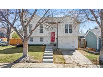 Charming two-story home with a white exterior, red door, and landscaped front yard at 19792 E Bates Dr, Aurora, CO 80013