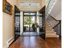 Inviting foyer features double doors, hardwood floors, staircase, and plenty of natural light at 2552 E Alameda Ave # 16, Denver, CO 80209