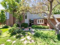 Charming brick home with well-manicured lawn, mature trees, and stone walkway leading to the front door at 2552 E Alameda Ave # 16, Denver, CO 80209