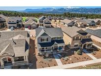 Stunning home with mountain views, gray siding, dark roof, and manicured landscaping in a vibrant neighborhood at 668 Sage Forest Ln, Monument, CO 80132
