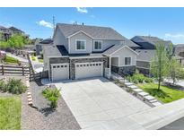 Charming two-story home featuring a stone-accented facade, three-car garage and landscaped front yard, creating an inviting curb appeal at 6630 S Coolidge Ct, Aurora, CO 80016