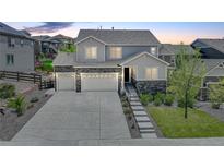 Charming two-story home with a three car garage, stone accents, landscaped front yard and long driveway at 6630 S Coolidge Ct, Aurora, CO 80016