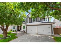 Charming two-story home boasts a three-car garage, well-manicured lawn, and lovely landscaping, perfect for curb appeal at 7027 Chestnut Hill St, Highlands Ranch, CO 80130