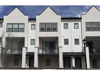 Exterior of a townhome featuring a balcony, white siding, and black window trim at 8311 Parkland St, Broomfield, CO 80021