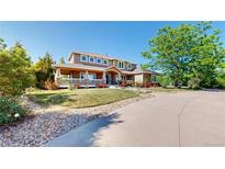Beautiful home showcasing a covered front porch, stone accents, and mature landscaping at 9353 E 146Th Ave, Brighton, CO 80602