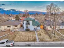 Charming two-story home with green roof, white painted brick, balcony and inviting curb appeal on a large lot at 3550 Eudora St, Denver, CO 80207